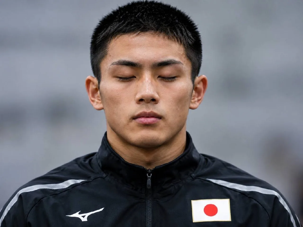 身穿日本代表隊黑色外套的柔道選手，賽前閉目專注