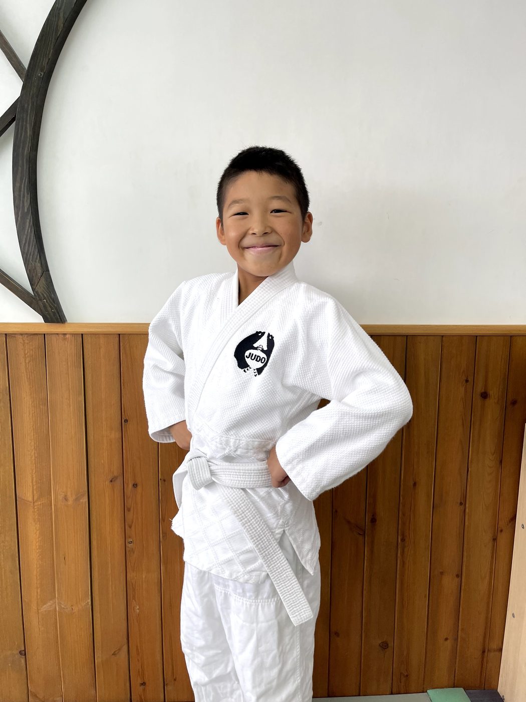 Kuma Dojo 兒童柔道學生穿著白色柔道服微笑
