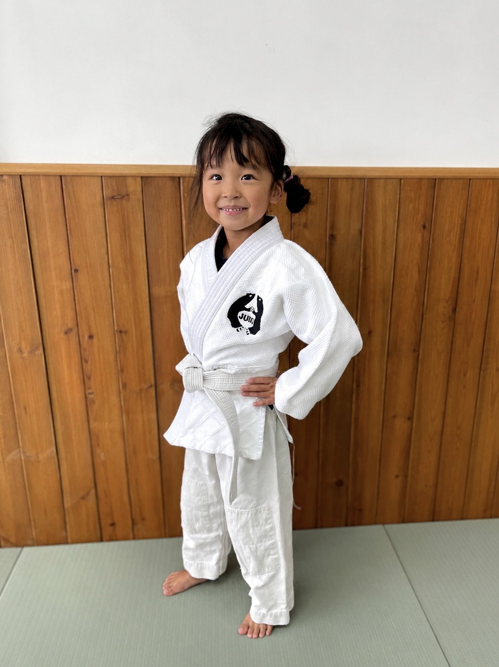 Kuma Dojo child judoka smiling in a white judogi